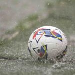 Pallone da calcio rotola su un campo in erba