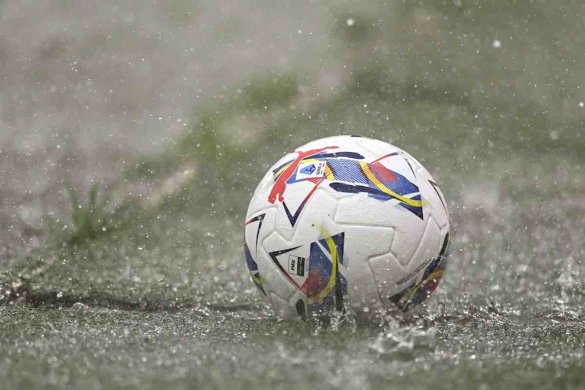 Pallone da calcio rotola su un campo in erba